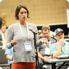 WasteExpo attendee standing in front of a micrpohone in the aisle asking a question at a conference session