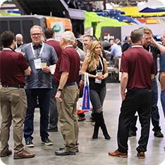 Group of attendees hacing a conversation on the WasteExpo show floor