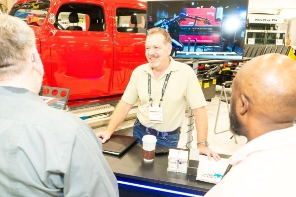 Group of attendees hacing a conversation on the WasteExpo show floor