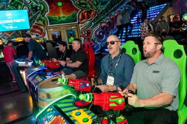 2 men playing a laser shooting game at the WasteExpo Welcome Reception