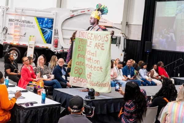 Model holding statement written on large canvas at Trashion