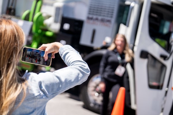 Person taking photo of a colleague about to ride in the MACK truck
