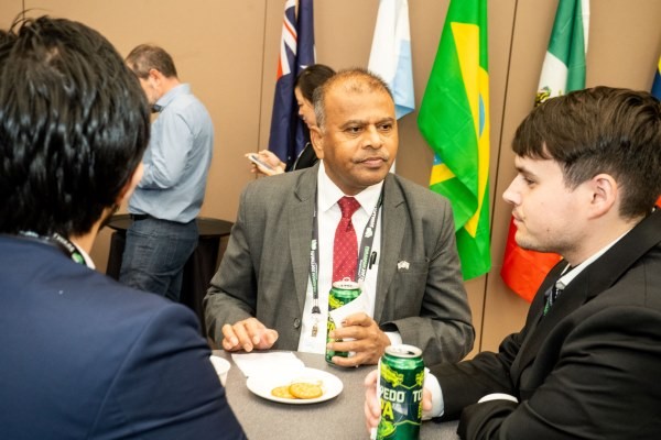 3 attendees eating and drinking at the international reception