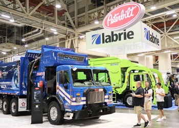 Exhibitor booth with waste trucks on the WasteExpo show floor