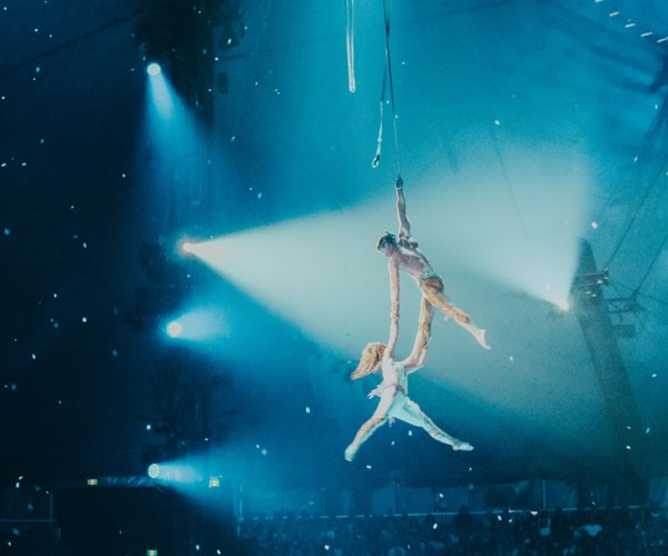 2 acrobats in the air at a show in Las Vegas